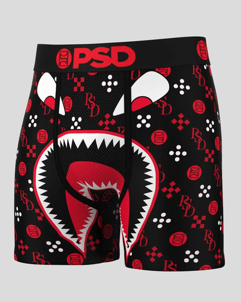 Black and red PSD boxer briefs with graphic monster face design, white teeth, and repeating logo pattern.
