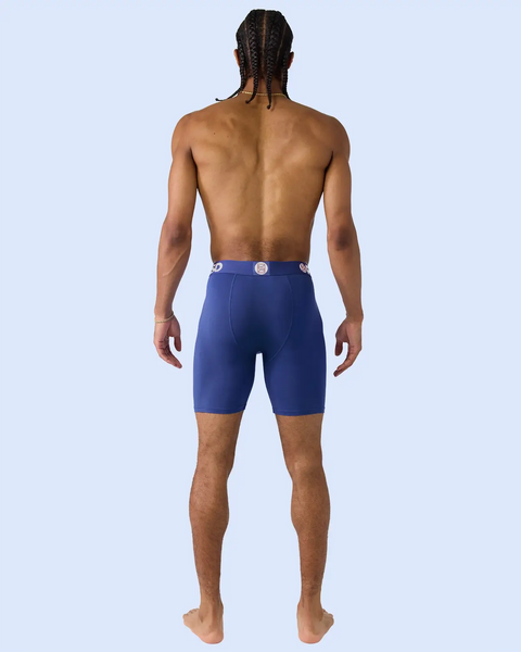 Man wearing blue modal boxer briefs with branded waistband, shown from behind.