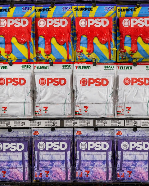 White disposable to-go cup with red PSD logo, displayed in retail packaging on store shelf.