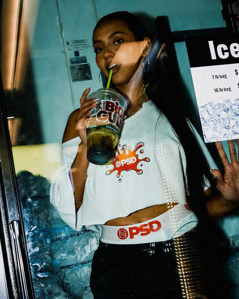White graphic tee featuring red and orange splash design with 7-Eleven branding on front.