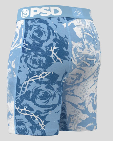 PSD blue boxer shorts with rose and thorn branch pattern on light gray background.